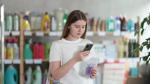 Girl buyer scans qr code on razor kit label Stock Footage 310531465