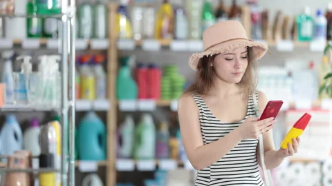 Girl buyer scans qr code on sun protection cream label, uses link to get Stock Footage 313877311