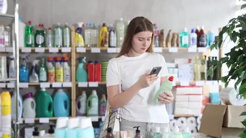 Girl buyer scans qr code on dishwashing soap label Stock Footage 344844102