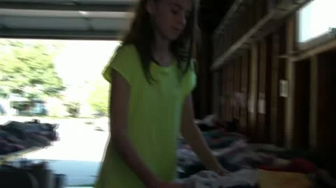 Girl Buys Clothes at Garage Sale Stock Footage