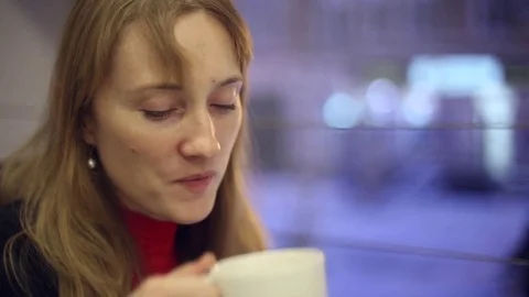 The girl in the cafe drinking tea and eating a bun Stock Footage 70281388