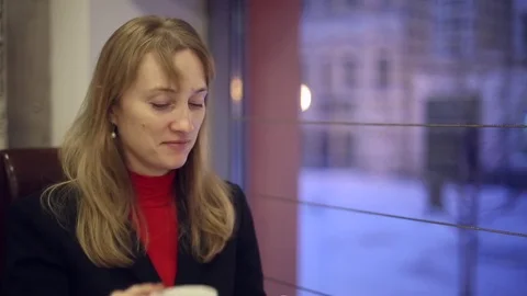 The girl in the cafe drinking tea and eating a bun Stock Footage 70281397