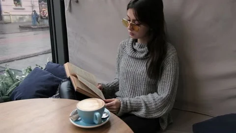 Girl in cafe read a book Stock Footage 90541373
