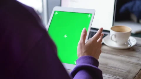 Girl in cafe using iPad tablet viewing green screen press browsing chroma key Stock Footage 169568249