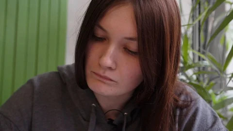 Girl in a cafe, write with a pen in a notebook and thoughtfully check the task Vidéo 126951498