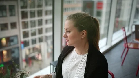 Girl with camera drinks coffee in a cafe Stock Footage 128439636