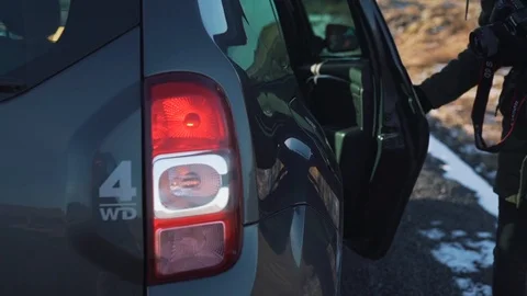 A girl with a camera getting into the car Stock Footage 89803273