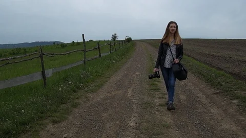 Girl with a camera in her hands walking Stock Footage 126914904
