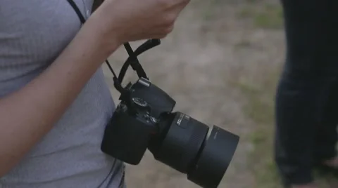 Girl with the camera on her neck looking at smartphone Stock Footage 61248554
