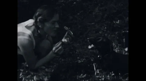 Girl camper feeding a puppy at campsite Stock Footage
