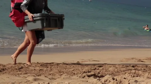 Girl carrying plastic cooler, sandy beach, ocean, sunny day Stock Footage 57463554