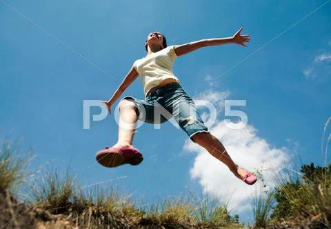 Girl in casual clothing jumping in the park Stock Photos