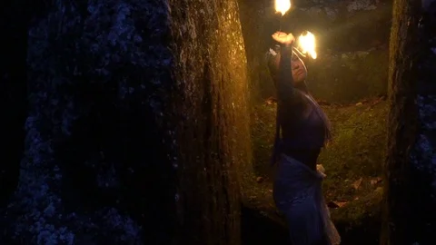 The girl in the cave is dancing dangerously with fire in her hands. Stock Footage 113318412