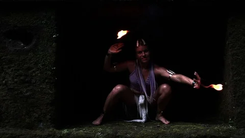 The girl in the cave is dancing dangerously with fire in her hands. Stock Footage 113318904