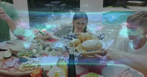 Girl centered watching man reaching passing bread basket at family meal while 스톡 동영상 334120470