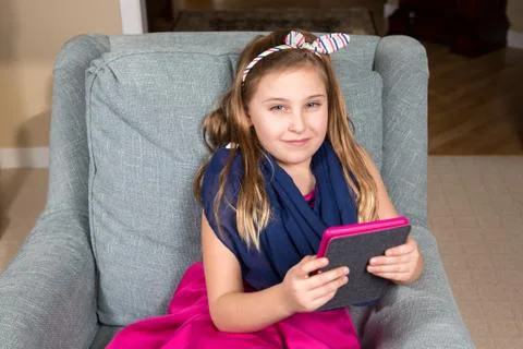 Girl in a Chair with a Tablet Stock Photos