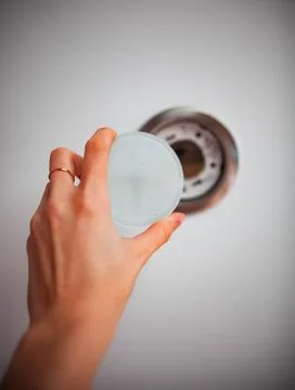 The girl changes the light bulb in the stretch ceiling Stock Photos