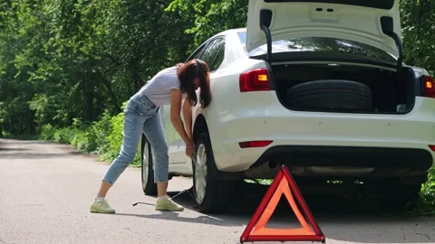 The girl changes the wheel of the car. Stock Footage 246819546