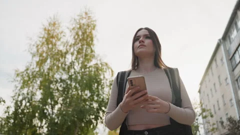 Girl checking app, Woman using phone near trees, Young woman scanning delivery Stock Footage 329578843