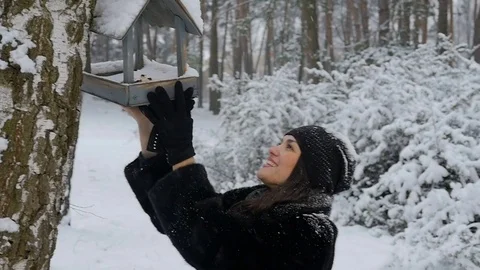 Girl is checking the bird feeder in the winter forest. SlowMotion Stock Footage 71508087