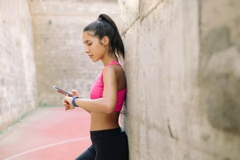 Girl checking data from fitness tracker in a smartphone app Stock Photos