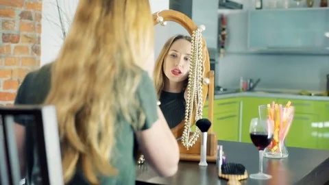 Girl checking her appearance in the mirror and chatting on cellphone Stock-Footage 70398970