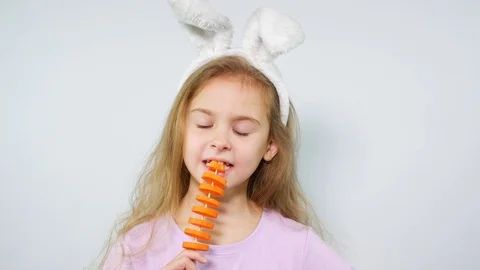The girl cheerfully eats carrots on a white background. Stock Footage 105128583