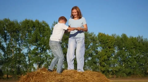 A girl with a child playing on a haystack Видео 67322764