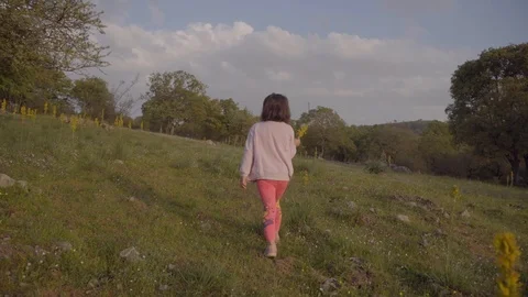 Girl child walking alone in nature from behind Stock Footage