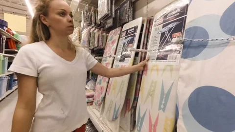 The girl chooses the ironing board Stock Footage 78699853