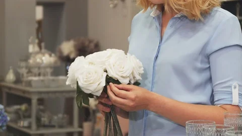 The girl is choosing flowers to decorate her house Stock Footage