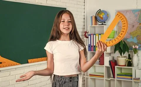 Girl in classroom school with protractor math tool ruler, geometry education Stock Photos