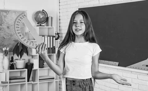 Girl in classroom school with protractor math tool ruler, geometry education Stock Photos