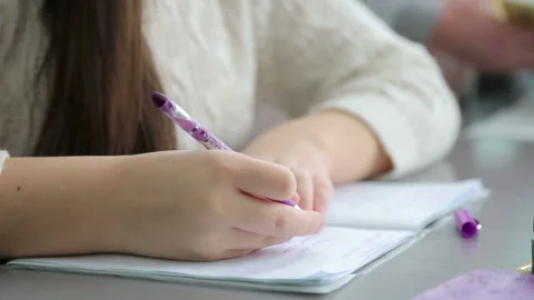 The girl in the classroom writes in a notebook Video stock 86684138