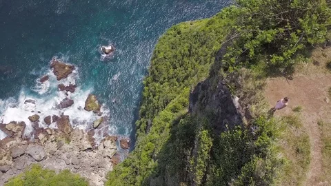 Girl on the cliff top down view aerial footage of Indonesia Stock Footage 101837829
