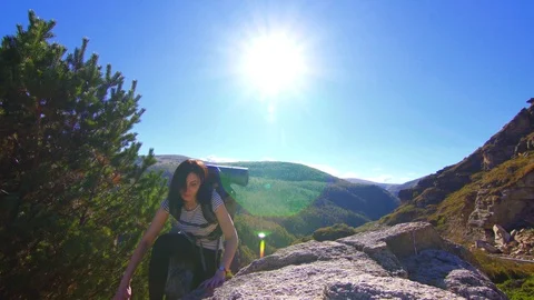 Girl climber with backpack on back open arms on mountain peak Stock Footage 95548413