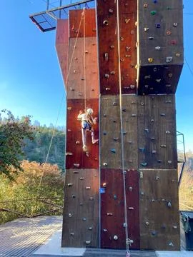 Girl climbing, using safety elements and climbing on artificial wall. Stock Photos