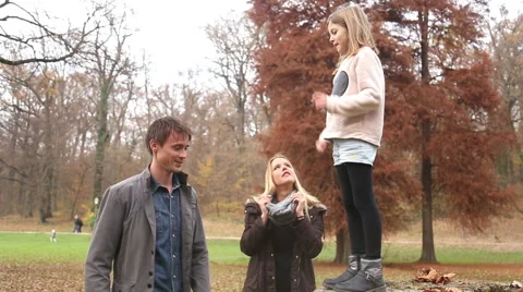 Girl climbs on father's back from tree stump Stock Footage 59554008