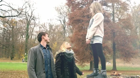 Girl climbs on father's back from tree stump Stock Footage 59554017