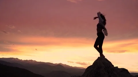 Girl climbs mountain on top peek Stock Footage