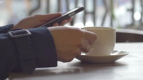 Girl in coat surfing the web while sipping coffee indoors Stock Footage 67056931