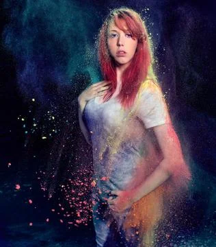 Girl with colored powder exploding around her Foto stock