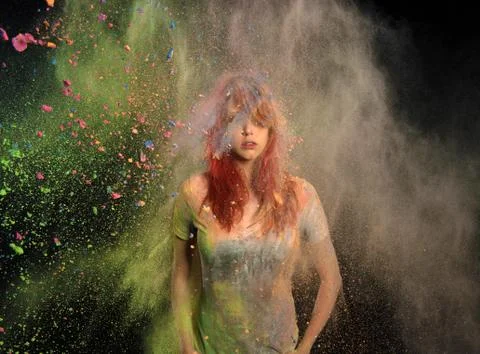 Girl with colored powder exploding around her Stock Photos