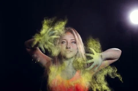 Girl with colored powder exploding around her and into the background. Stock Photos