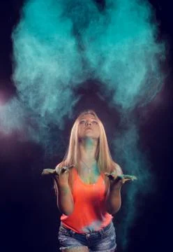 Girl with colored powder exploding around her and into the background. Stock Photos