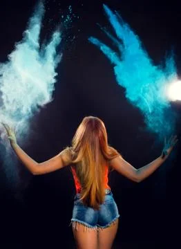Girl with colored powder exploding around her and into the background. Stock Photos