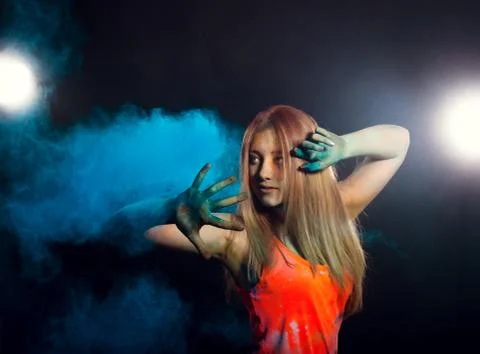 Girl with colored powder exploding around her and into the background. Stock Photos