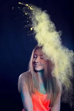 Girl with colored powder exploding around her and into the background. Stock Photos