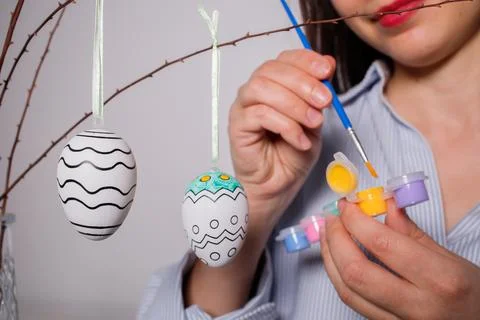 Girl coloring decorative Easter eggs for Easter tree decoration at home bef.. Stock Photos