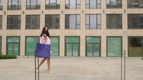 Girl comes with a blue bag near modern building. Stock Footage
